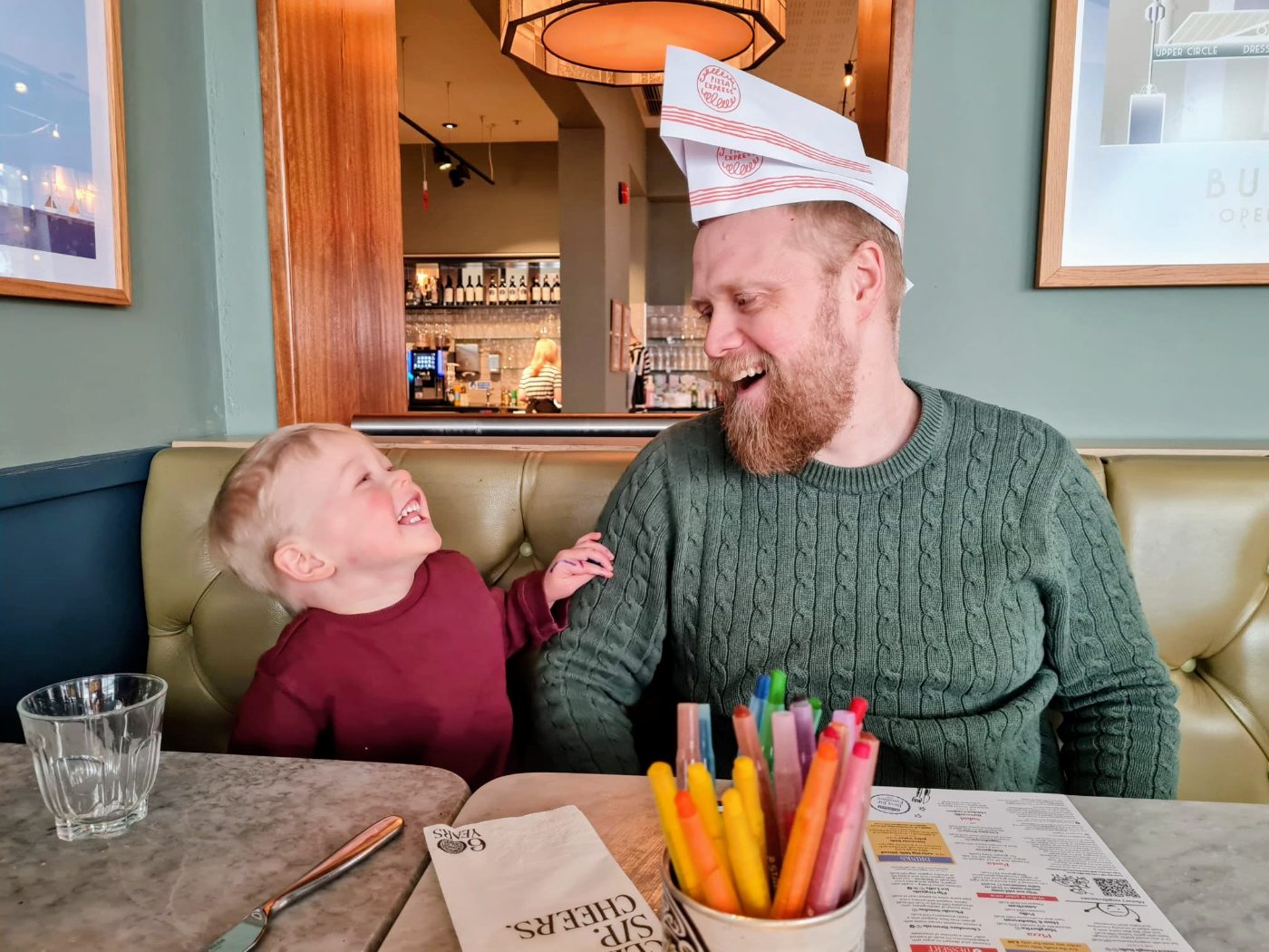 Edmund and his son Gideon laughing together at a restaurant table